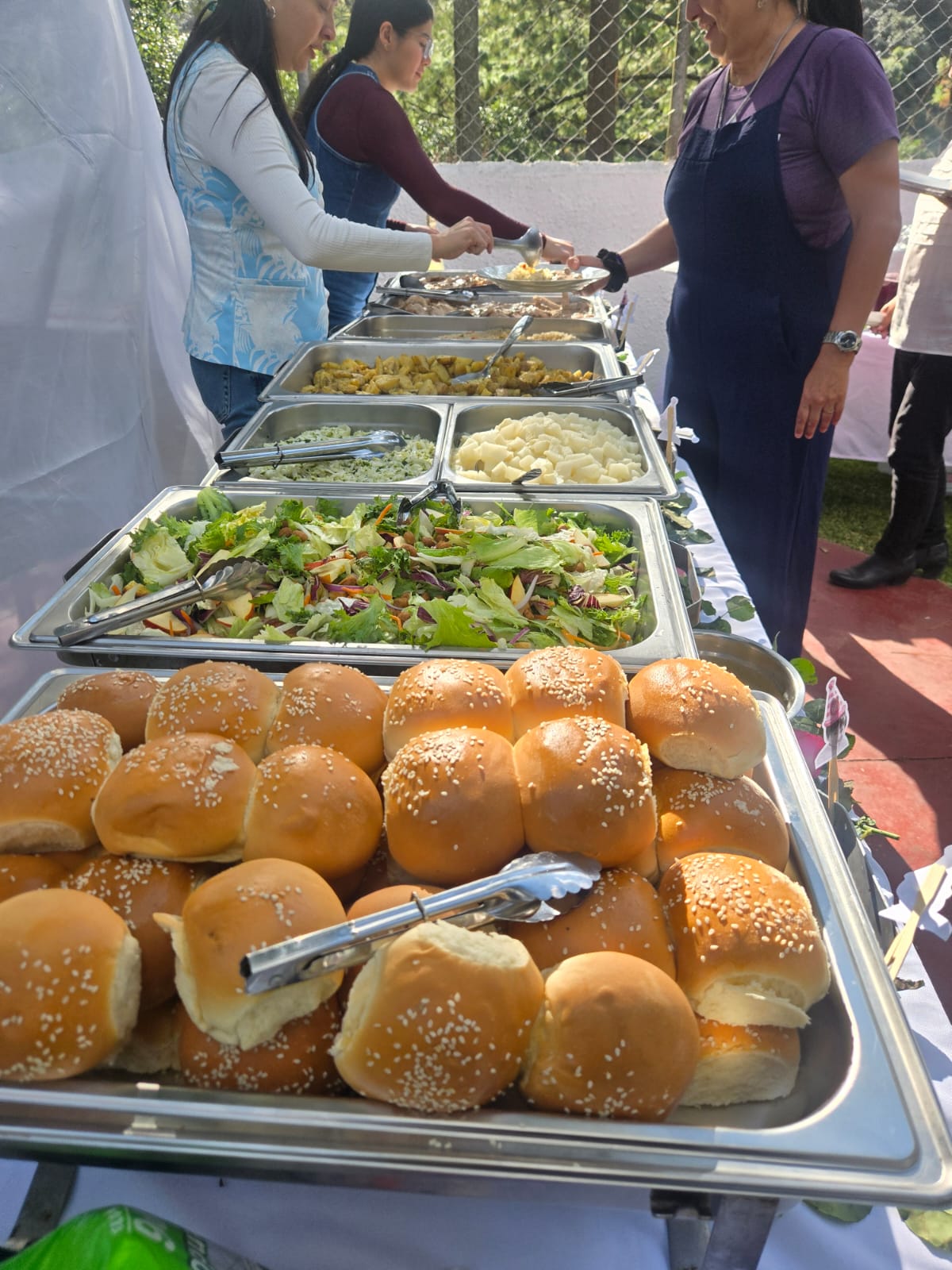 Línea de buffet con panes, ensaladas y guarniciones
